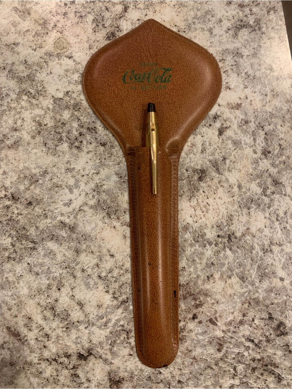 vintage-style brown leather pen sleeve or pouch embossed with the classic "Drink
